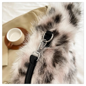 Macro detail of plush faux fur bag strap with silver metal clasp and cow print pattern