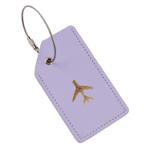 Detail view of purple leather luggage tag with gold airplane logo and steel wire ring