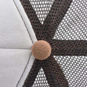 Macro view of mesh baseball cap crown showing white twill and brown breathable mesh fabric