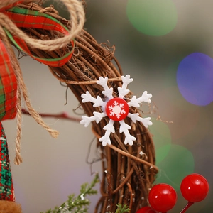 Macro shot of rustic rattan wreath with plaid fabric, felt snowflake and red berries