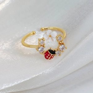 Detail of adjustable flower ring with ladybug element and sparkling zircon stones