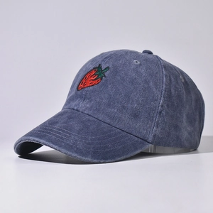 Dettaglio ricamo fragola su cappellino da baseball in denim lavato blu scuro lucido