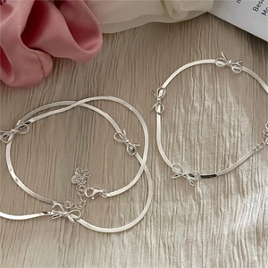 Detailed view of silver snake chain necklace with 3D bow accents and adjustable lobster clasp