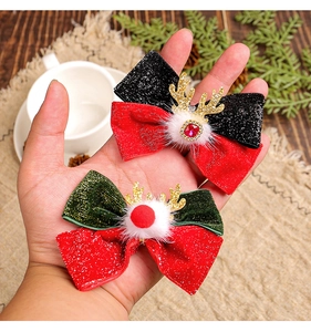 Detail of Christmas reindeer antler hair clips with velvet bows and pompom decorations