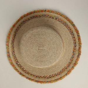 Dettaglio cappello di paglia boho con frange colorate e trama a spirale intrecciata
