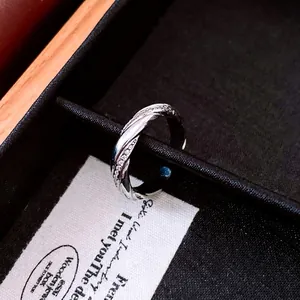 Elegant twisted silver ring with micro-set zircon stones in a black velvet jewelry box