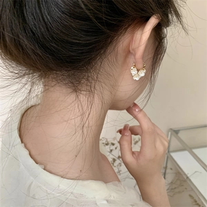 Elegant gold plated heart flower earrings with white pearls on female model side view