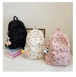 Three corduroy backpacks with cherry print and plush pendants in black white and pink