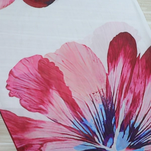 Macro view of mesh fabric featuring pink floral prints and lightweight texture details