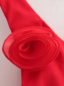 Detail shot of a bright red 3D chiffon rose flower decoration on a halter neck top