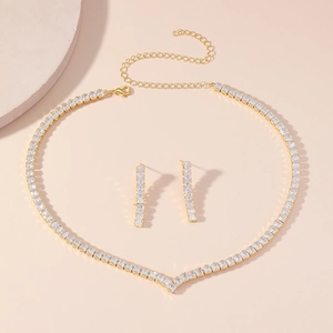 Detail of gold-plated jewelry set featuring V-shaped necklace and square zircon earrings
