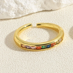 Close-up of adjustable gold ring featuring vibrant rainbow baguette cut cubic zirconia