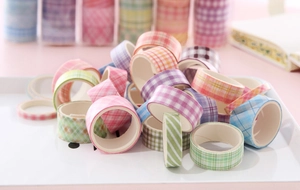 Close-up of pastel grid washi tape rolls in pink, blue and green on a white tray