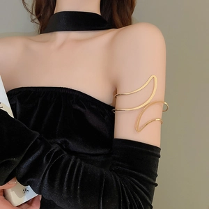 Gros plan du bracelet de bras doré poli au design ondulé sur fond de velours noir élégant