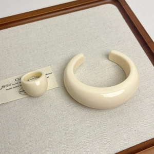 Minimalist cream resin jewelry set with a wide open cuff bangle and a thick smooth ring