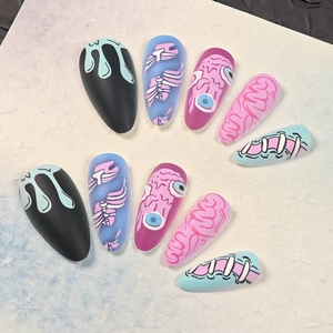 Halloween press-on nails with matte monster patterns including eyeballs and brain textures