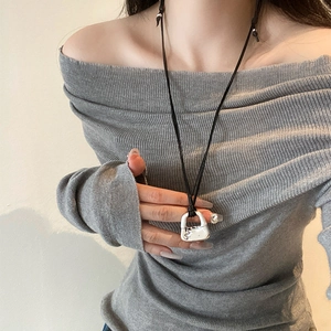 Collana con ciondolo a serratura argento e cordino nero indossata da una modella