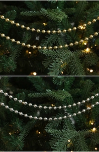 Detailed view of shiny gold and silver Christmas bead chain hanging on tree branches