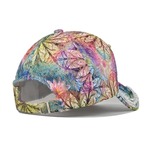Détail de la casquette avec motif feuille coloré, tissu pailleté et bord en perles