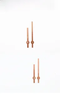 Detail of rose gold metal clock hands set with minimalist design and round hole mount