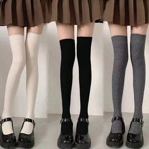 Detailed knit texture of over-knee socks in cream, black, and dark grey colors