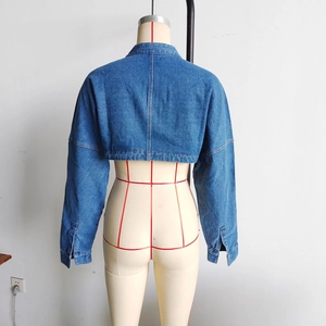 Rear view of a short blue denim jacket on a mannequin showing long sleeves and hem detail