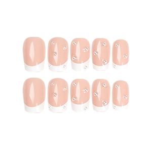 French tip press-on nails in nude pink with white edges and delicate pearl accents