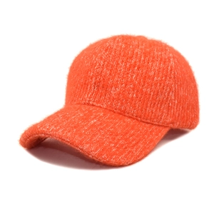 Detailed close-up of orange plush baseball cap showing fluffy faux mohair texture