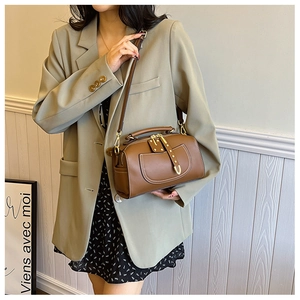 Sac Boston en cuir marron avec poche zippée à l'avant et rivets dorés de luxe