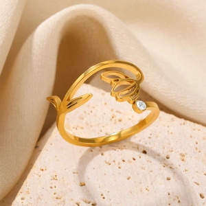 Macro shot of gold tulip ring with a white zircon on a textured stone surface