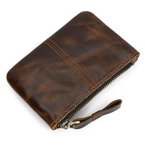 Close-up of vintage brown leather coin purse showing premium texture and metal zipper