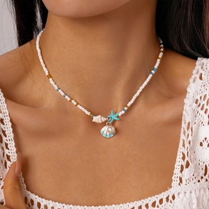 Close-up of beaded necklace featuring sea shells, starfish and pearl charms on a model