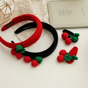 Detailed set of velvet headbands and knitted cherry clips on elegant white lace background