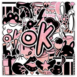 Close-up of pink and black glitter stickers with cartoon party icons and happy slogans