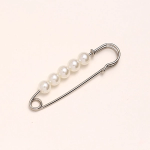 Detail of silver safety pin with five white faux pearls for waist adjustment