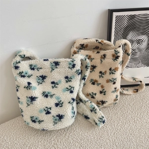 Detail view of floral plush bucket bags with secure magnetic closure and wide soft straps