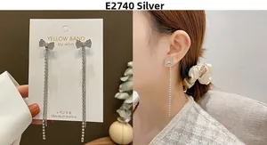 Detail view showing long silver tassel earrings with crystal bows and model showcase