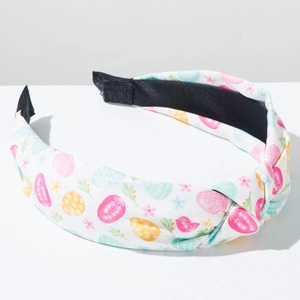 Detail showing knotted fabric headband with Easter egg and floral prints on white cloth