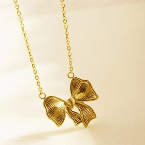 Golden bow pendant necklace in stainless steel with elegant ribbon design for women