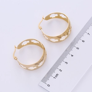 Close-up of golden wide-band hoop earrings with rectangular cutouts showing 3.5cm size