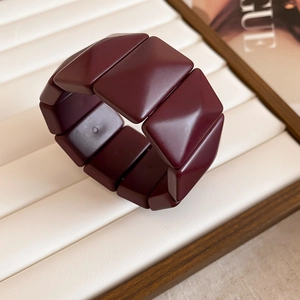 Detail shot of deep red geometric resin blocks on a flexible elastic bracelet band