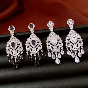 Exquisite chandelier earrings with purple and white cubic zirconia on a leather stand