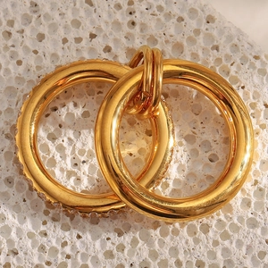Macro view of 18K gold plated double-layer rings with cubic zirconia on white coral stone