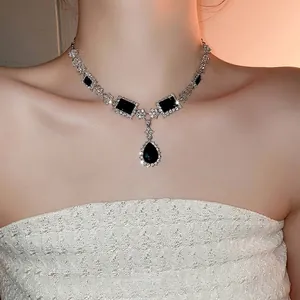 Elegant geometric silver necklace set with pear-shaped black gemstones and white diamonds