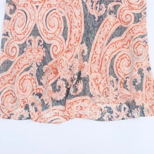 Détail de l'ourlet de robe à motif paisley orange et crème sur tissu en mousseline légère