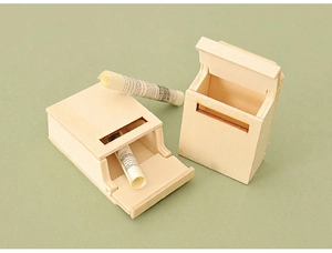 Miniature wooden mailbox model with open lid showing rolled paper for dollhouse scene