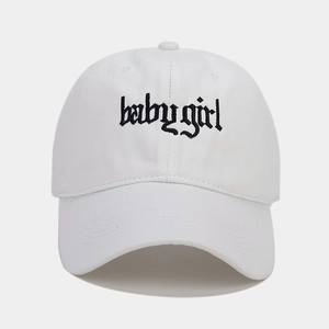 Close-up of black gothic Babygirl embroidery on a white cotton baseball cap detail