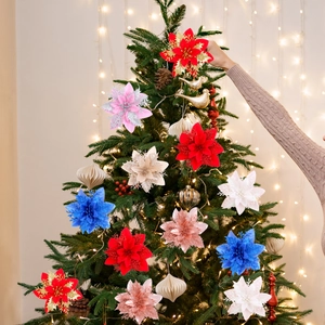 Three-layer glittering Christmas poinsettia flowers being decorated on a festive Xmas tree