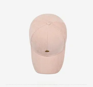 Top view of pink herringbone baseball cap with small gold metal plate detail
