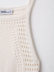 Detail of crochet halter neck mini dress showing intricate hollow-out knit patterns and size S tag